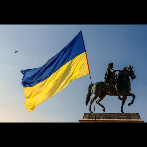 Uktainian flag close the statue on the Bellecour place, Lyon, France. Photojournalism, Demonstration against the war in Ukraine