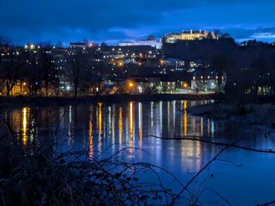 Stirling Castle lit up by night, seen over the River Forth