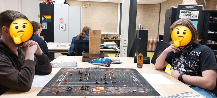 To Arduino programming scummers enjoying their first game of blood bowl. They are scratching their chins