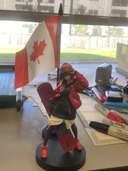figurine of Ruby Rose from RWBY Ice Queendom posing with Canadian flag behind her.