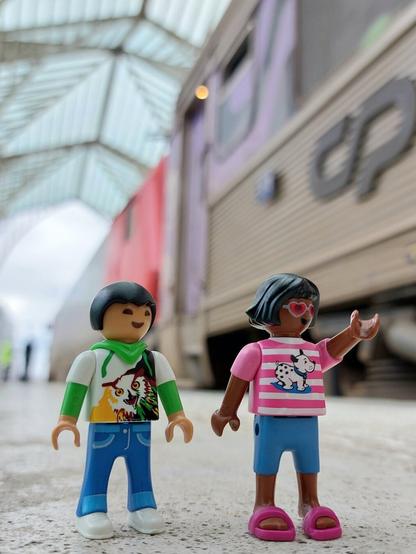Menino e menina playmobil junto de comboio intercidades cinza, dentro da estação do oriente em Lisboa, Portugal