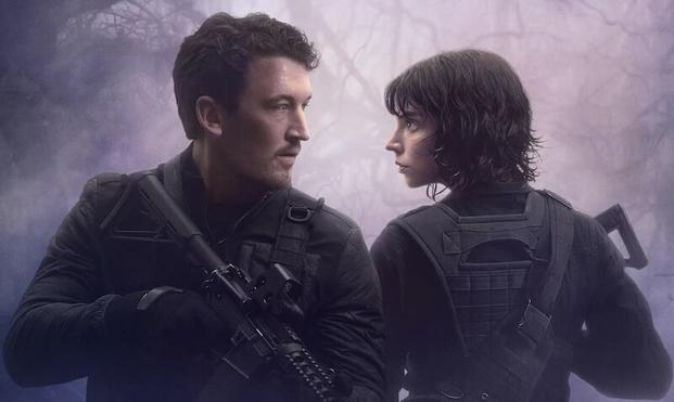 Miles Teller and Anya Taylor-Joy stand back to back in a scene from The Gorge. Both hold guns.