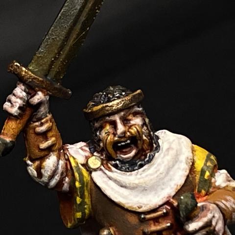 A North Star Figures Oathmark King Figure. The miniature is painted in warm earthy tones. His eyes are glowing, his raised sword is rusted and grimy.