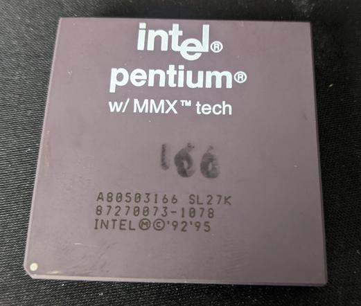 A ceramic package 166MHz Intel Pentium CPU with MMX technology. The number 166 is messily drawn on in marker.