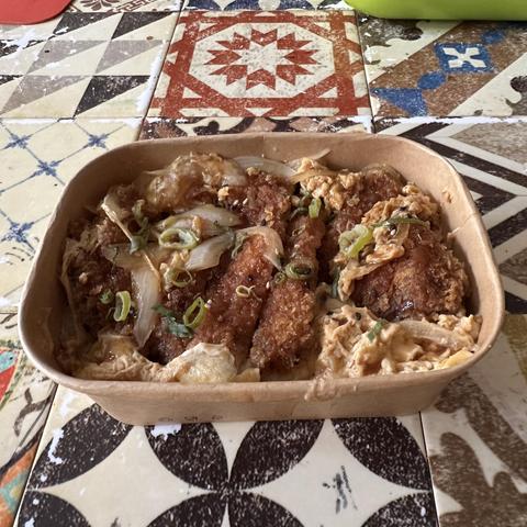Take Away box with katsudon inside, a dish of rice scrambled eggs and breaded pork cutlet