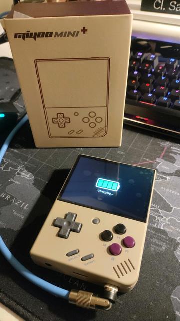 Foto del Miyoo mini+ in carica vicino alla sua scatola