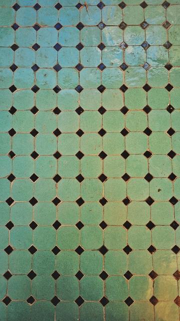 pattern in ceramic tiles, 4 smaller black squares rotated 45° and positioned at the top left edge of a bigger green-yellow square sitting flat. And then repeated that way many times. 98+ green ones, 112 black ones.