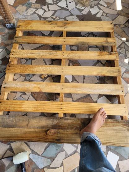 My foot resting on a pallet as I prepare to break it down to use in other home projects.