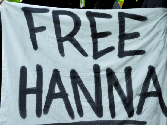 Nahaufnahme eines weißen Banners auf welchem in schwarz FREE HANNA steht