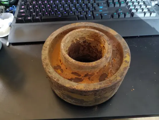 A photo of a very rusted steel wheel about 8 inches wide.