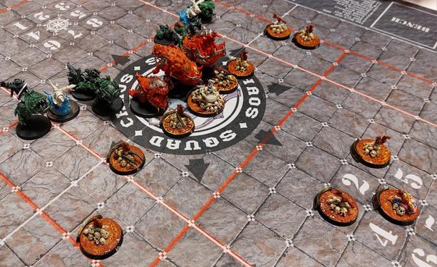 Bunch of squirrels on skull piles with their friendly white bunny on a dragon skull facing off a bunch of squigs with their goblin buddies on a blood bowl pitch