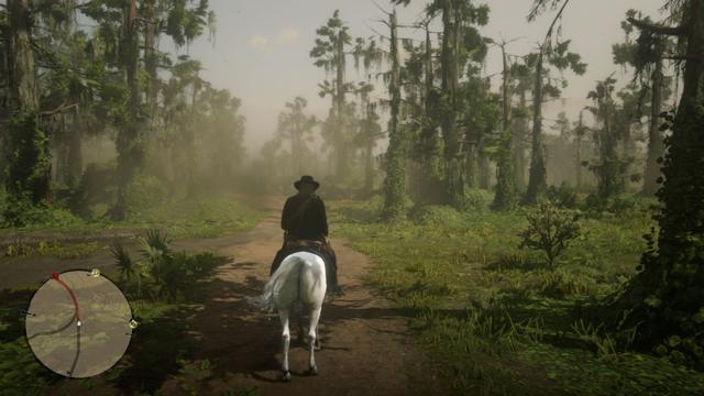 In this vivid scene from a video game, a solitary figure on horseback is journeying down a muddy road surrounded by lush greenery and towering trees. The rider is clad in what appears to be a cowboy hat and holds a rifle, suggesting an adventurous or possibly combat-focused narrative. 
The UI elements, such as the mini map on the bottom left, give players a sense of direction and location, while the health bar on the top right indicates the player's current status in the game. The overall color palette is rich with greens and browns, setting the stage for an immersive outdoor adventure.