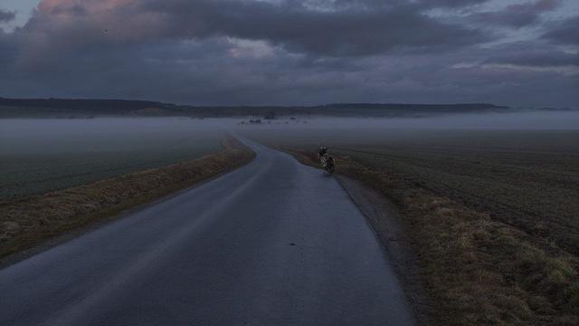 Kleine Straße bergab  führt in Richtung Nebelbank