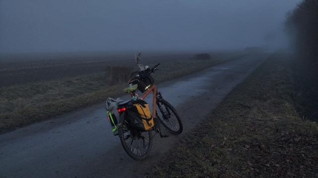 Rad auf einem Wirtschaftsweg, der Hintergrund ist in grauen Nebel gehüllt
