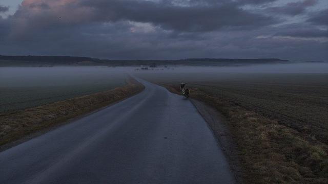 Kleine Straße bergab  führt in Richtung Nebelbank