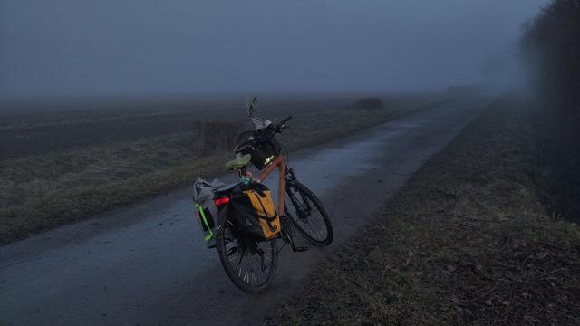 Rad auf einem Wirtschaftsweg, der Hintergrund ist in grauen Nebel gehüllt