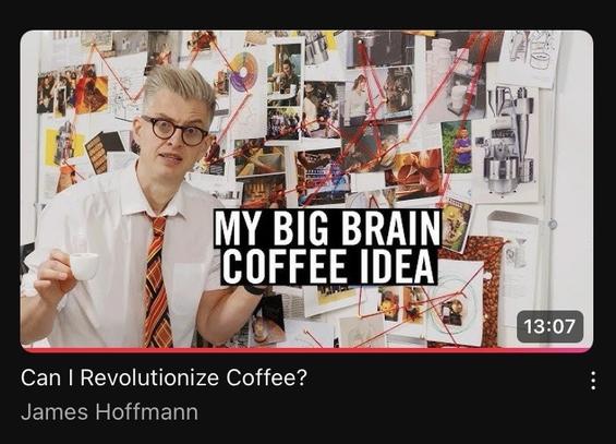 Captura de la portada de un vídeo de YouTube de James Hoffmann llamado “Can I Revolutionize Coffee?”: aparece James con camisa y corbata, con un espresso en la mano delante de una “pared de la conspiración”, con un montón de fotos y papeles enlazados por hilo rojo, y “MY BIG BRAIN COFFEE IDEA” sobreimpresionado.