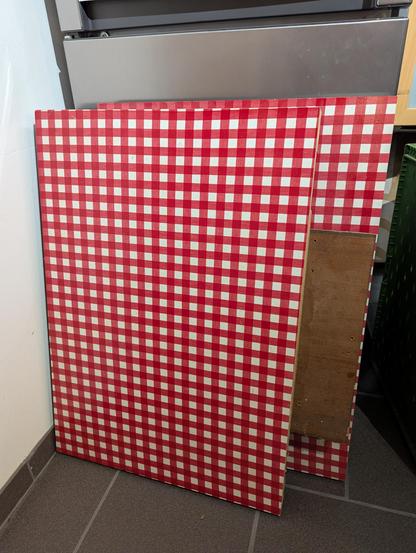 Foto von zwei massiven Holzplatten mit rot-weiß kariertem Furnier.