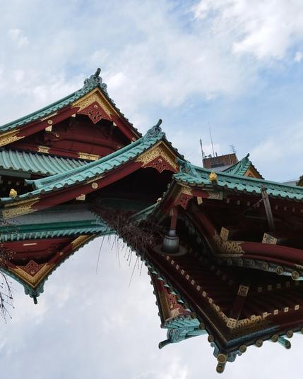 The bigger shrines often have elaborate, overlapping roofs with pointy corners. I've taken two pictures from different positions around this shrine, flipped one image upside down, and fitted these pictures together as if they were one object that's only roof to all sides. They are wooden structures painted red topped with tiles in a dark turquoise. Some of the sections carry shiny brass highlights.