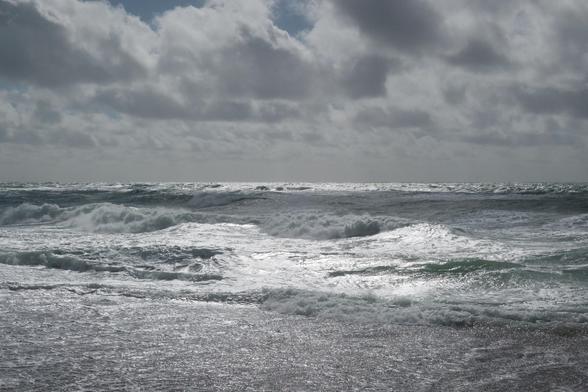 North Sea beach with incoming waves, the sky is overcast.