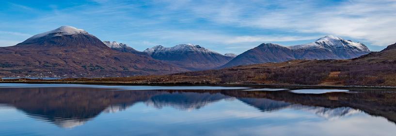 Snow topped hills and a still sea.