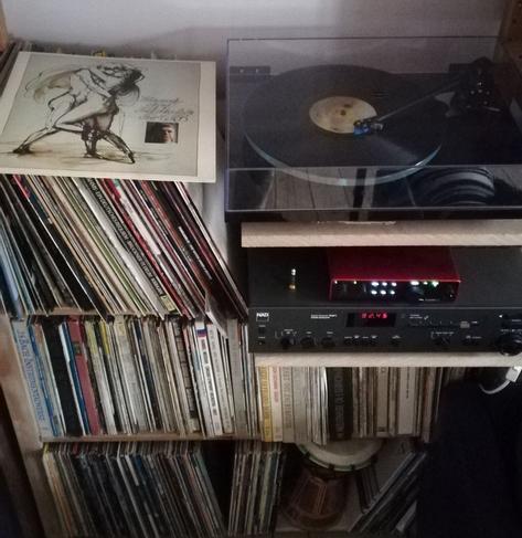 A record player and vinyl records. The place looks messy. The owner is no doubt a wicked person.
