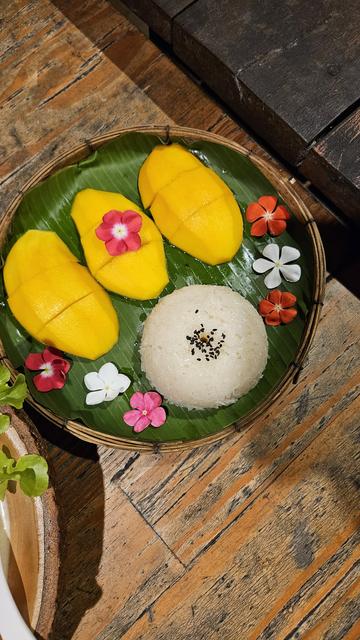 Plat de mango sticky rice avec des petites fleurs pour décorer