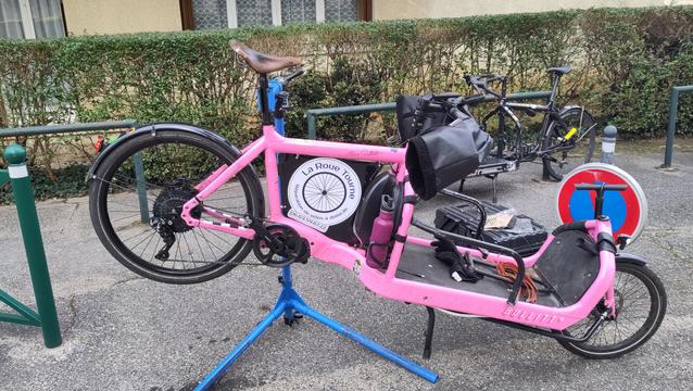 Velocargo rose sur le pied d'atelier avec un autre velocargo noir en arrière plan