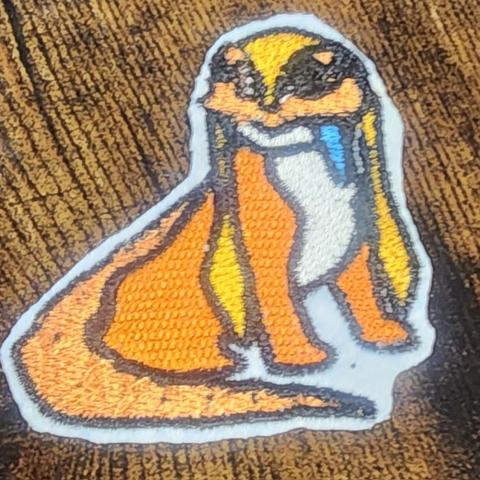 A Lizzard Doggo patch. orange, multi eyed dog lizzard animal with floppy ears and silly blue tongue, an iconic creature from the game Satisfactory.