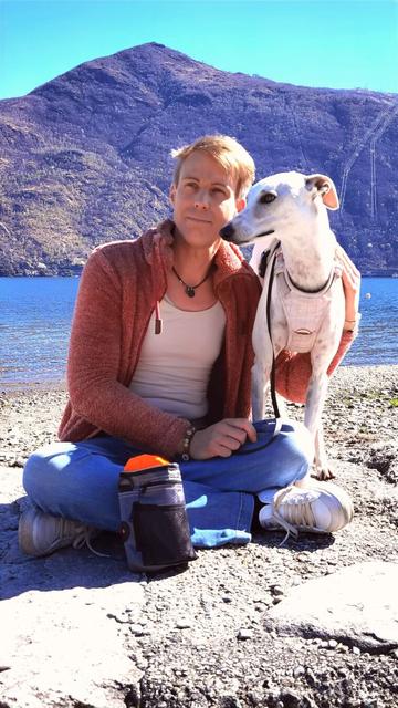 Ich sitze mit meinem Hund am Wasser