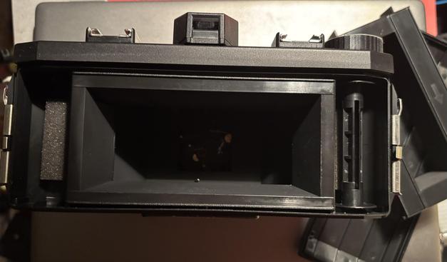 The open back of a plastic panoramic 120film camera, showing the normal (panoramic) mask.