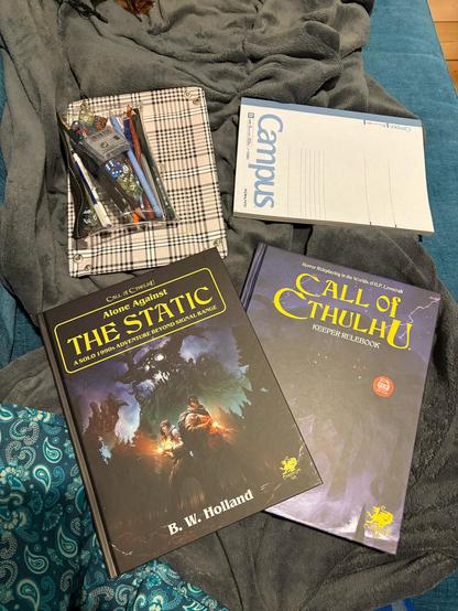 Photo showing Call of Cthulhu rulebook, alone against the static solo adventure and playing supplies.