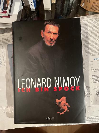 Spock in blauer Uniform mit dem bekannten Handzeichen und emotionslosem Ausdruck