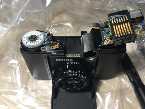 Minox 35 EL analog film camera in a clear plastic bag with its upper section deassembled