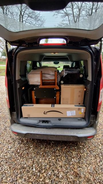 Car with tailgate raised showing it loaded to near roof level.
