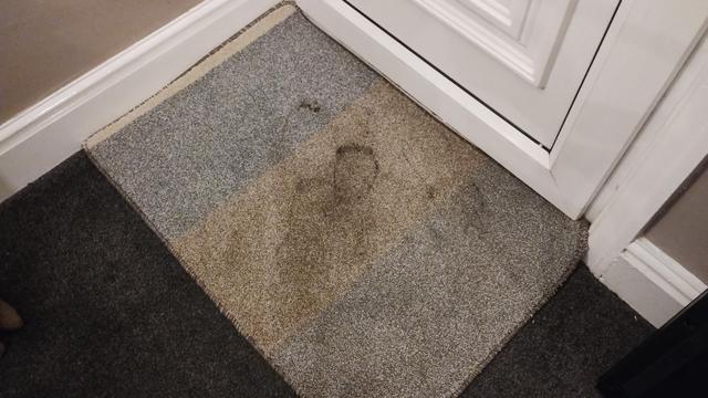 Door mat inside front door with muddy foot prints.