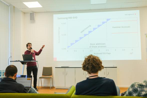 this is a picture of PhD student Jonas Juffinger presenting his paper "An Analysis of HMB-based SSD Rowhammer" at the uASC conference