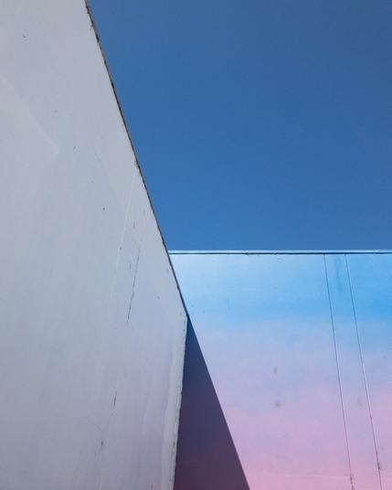 Close up of the corner of a building painted with a blue to pink gradient