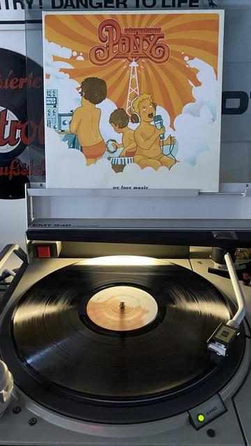 Vinyl Schallplatte „International Pony - We Love Music“ auf einem Plattenspieler.