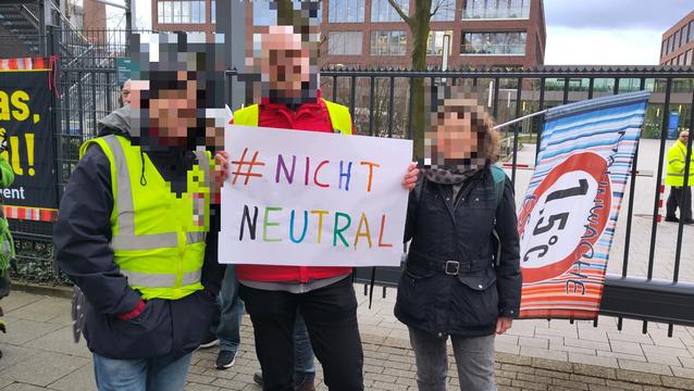 Drei Klimaaktivisten mit Plakat und Fahne