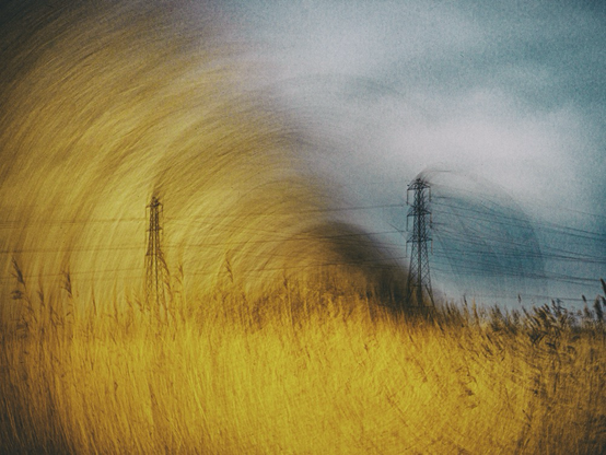 Intentional camera movement, image of power pylons and a golden field