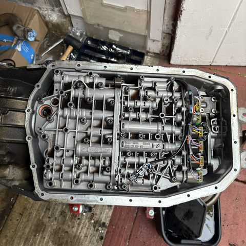 A view of the underside of a ZF 5HP19 five-speed automatic transmission removed from a 2003 BMW 530i, with the transmission oil pan removed to expose the valve body and solenoids.