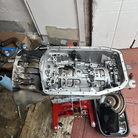 A view of the underside of a ZF 5HP19 five-speed automatic transmission removed from a 2003 BMW 530i, with the transmission oil pan and valve body removed. Several of the clutch drums are visible through openings in the transmission case.