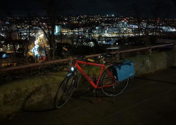 Fahrrad vor nächtlichem Stadtpanorama