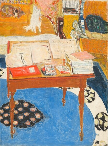 We look down onto papers and books piled on a small wooden table with delicate, spindle legs, with a dog and cat on a sofa. The scene is loosely painted with dabs and visible brushstrokes in butterscotch and golden yellow, azure and navy blue, apple red, and white. The square table takes up most of the bottom two-thirds of the composition. Its surface is almost entirely covered with a spread of papers and stacks of books, including two thick, white volumes near the front, right corner and a thin red book on the other front corner. Smaller squares between the books are painted with streaks and washes of turquoise blue, scarlet, and brick red. A tall, narrow vase with abstracted, ice-blue flowers sits behind the stacked books, to our right. Beyond that, at the back right corner of the table, a sheet of paper reads “ALBUM MUSICAL,” with the final L partially obscured by a piece of bubblegum-pink paper set askew atop the stacked books. The artist’s name appears in rust-red letters on a paper at the back left corner of the table: “Bonnard.” The rug beneath the table is dominated by a vivid, azure-blue ring. At the back edge of the rug, at the top left corner of the painting, a white cat sits and brown spotted dog lies on a mustard-yellow sofa, which has a wooden arm on the end we can see. There is a tangerine-orange chair next to it, in the upper right corner of the painting, and a teal-blue block there could be a pillow. The floor between the furniture is goldenrod yellow.