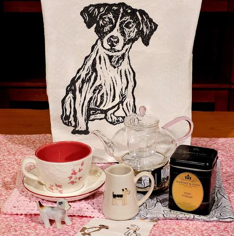 A tea tableau in white, black, and pink dedicated to terrier dogs. There are terriers on linen, flannel, china, and ceramic miniature. The tea is Tippy Yunnan black loose-leaf from Harney and Sons.
