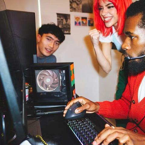 Three people surrounding Framework Desktop.