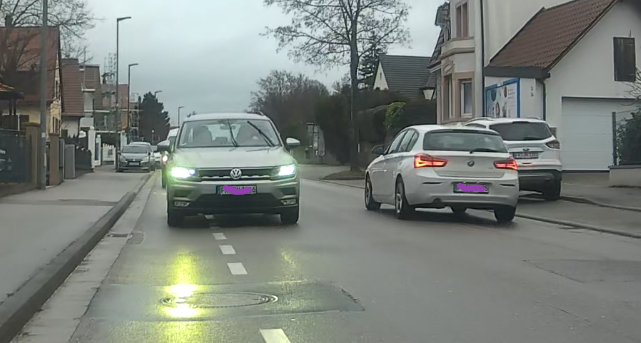 Blick nach hinten. Mehre Fahrzeuge befinden sich hinter mir zu ca. 60-70% auf dem Radfahrschutzstreifen. Begegnungsverkehr mit anderem KFZ, zwischen den Fahrzeugen aber jede Menge Platz