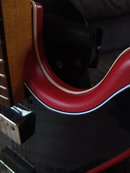 Close-up of the lovely, flawless slightly pale red vinyl body finish, as well as the piping-like bounding tracing the outline of the shape