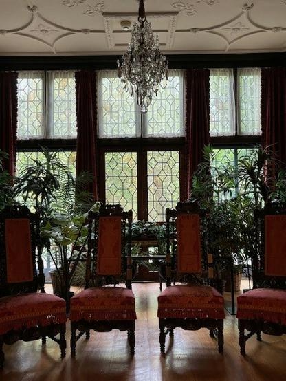 Color image of the Music Room, located on the main floor of the manor house at the circa 1915 Stan Hywet Hall and Gardens, Akron, Summit County, Ohio, USA. Image shows a bank of six tall leaded-glass doors under a brace of six tall leaded glass transom windows, the floor dressed in wood parquet, the ceiling dressed in high-relief plaster.